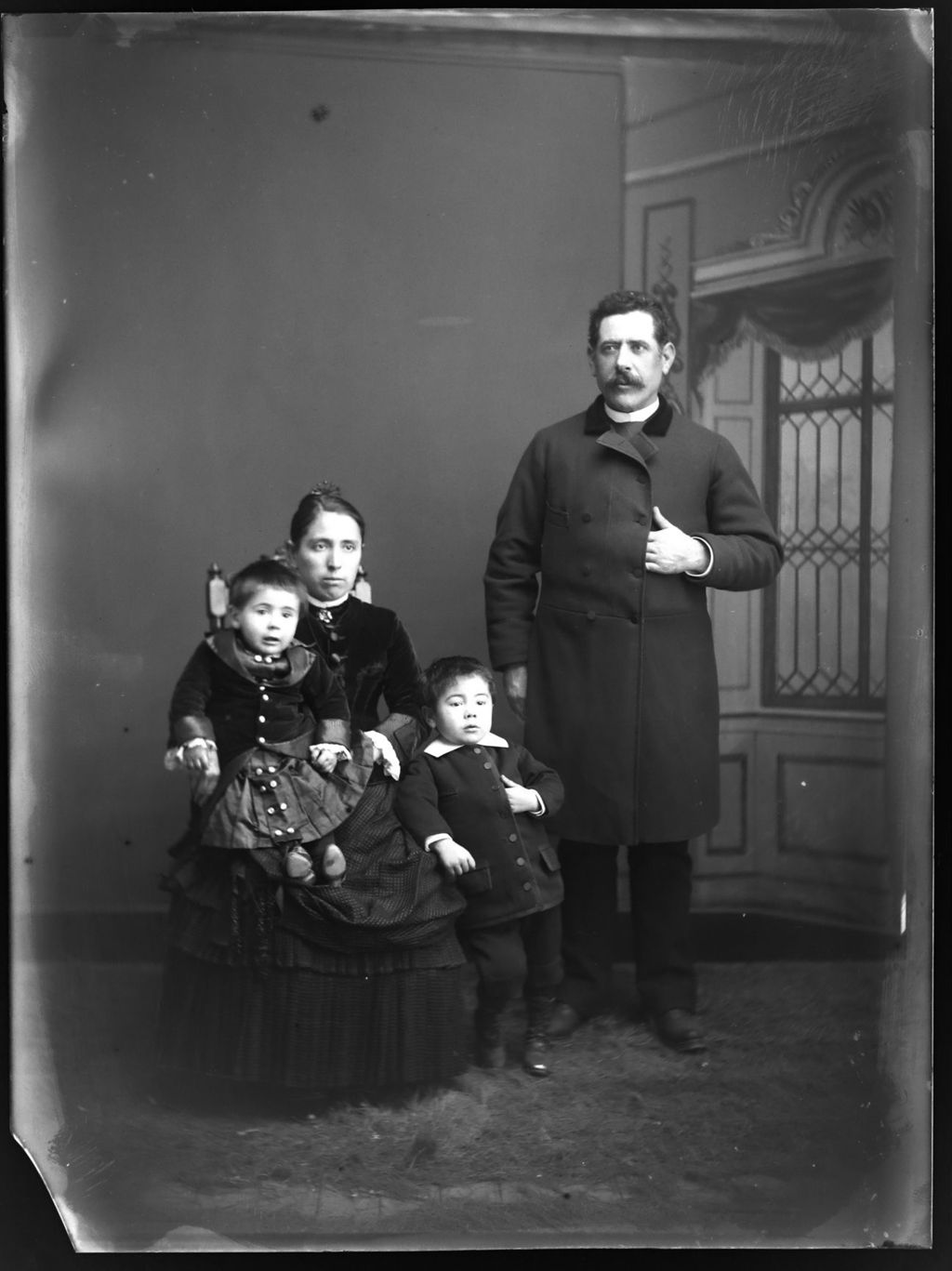 HOMBRE CON LA MANO EN EL PECHO Y FAMILIA.