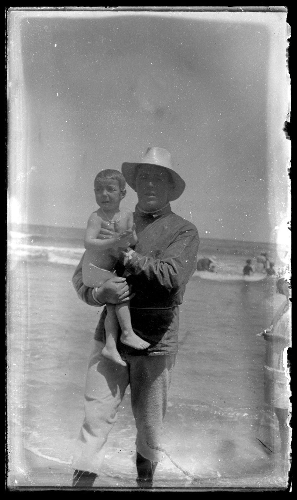 HOMBRE EN LA PLAYA CON NIÑO.