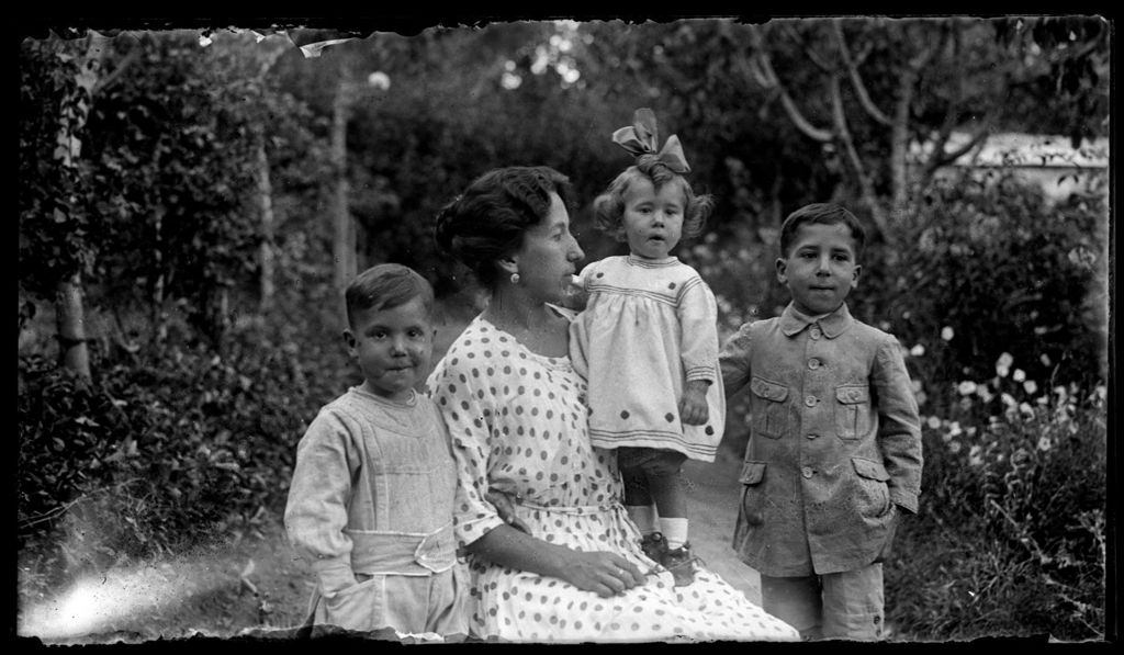 MUJER CON HIJOS EN JARDIN.