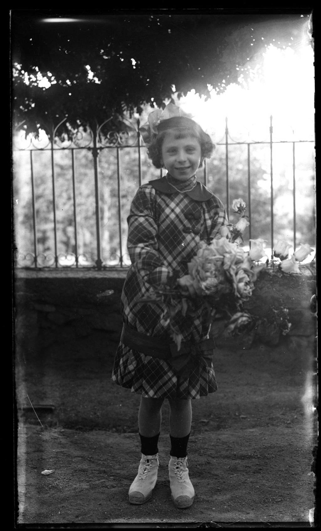 NIÑA RUBIA POSANDO CON VESTIDO DE CUADROS.