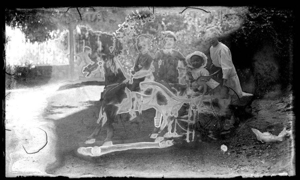 NIÑOS EN CABALLITO DE MADERA.