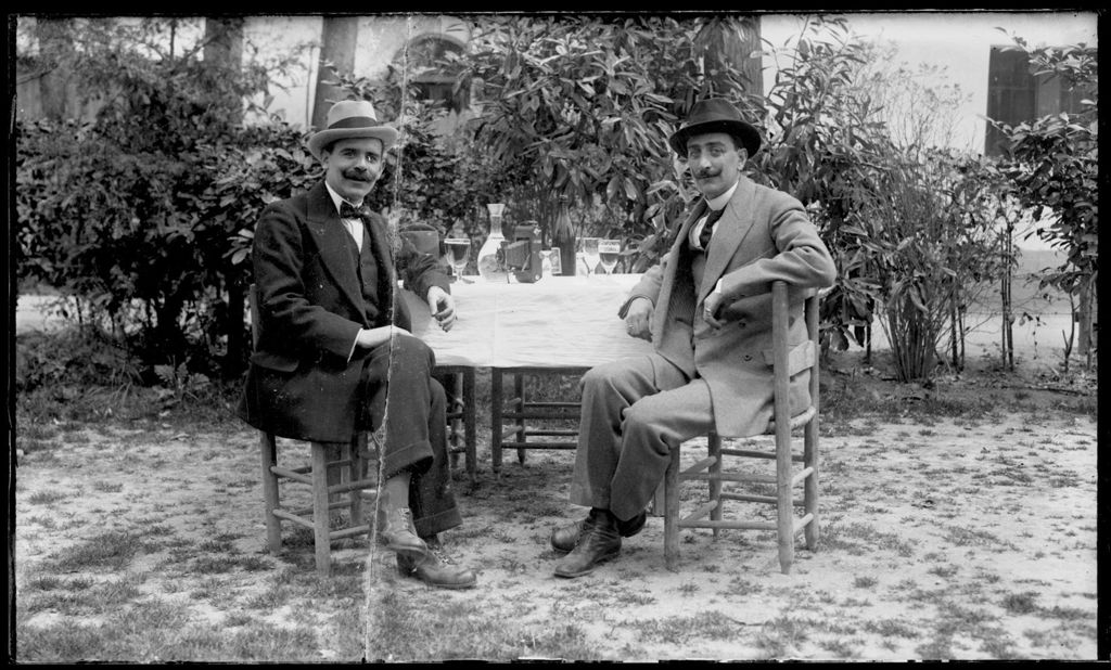 DOS HOMBRES CON BIGOTE TOMANDO UNA MAHOU.