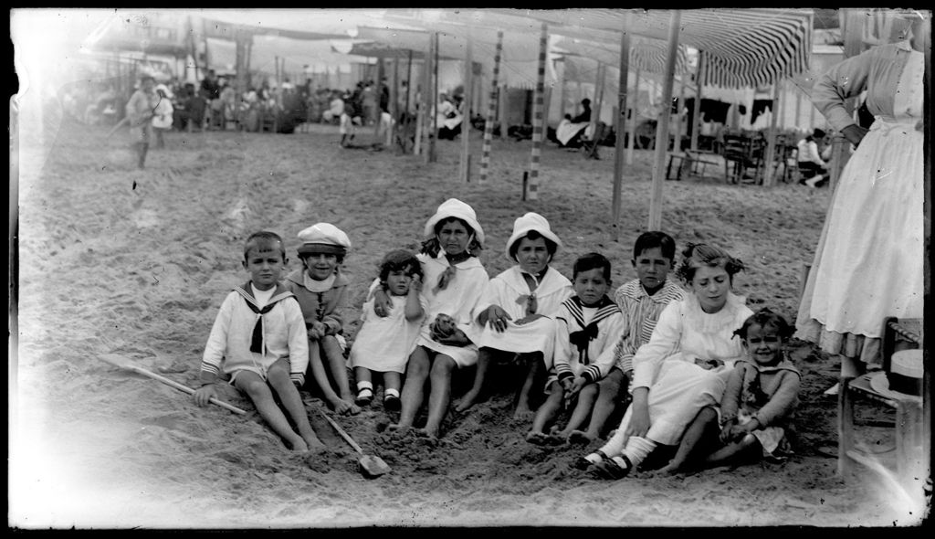 NIÑOS SENTADOS EN LA PLAYA.