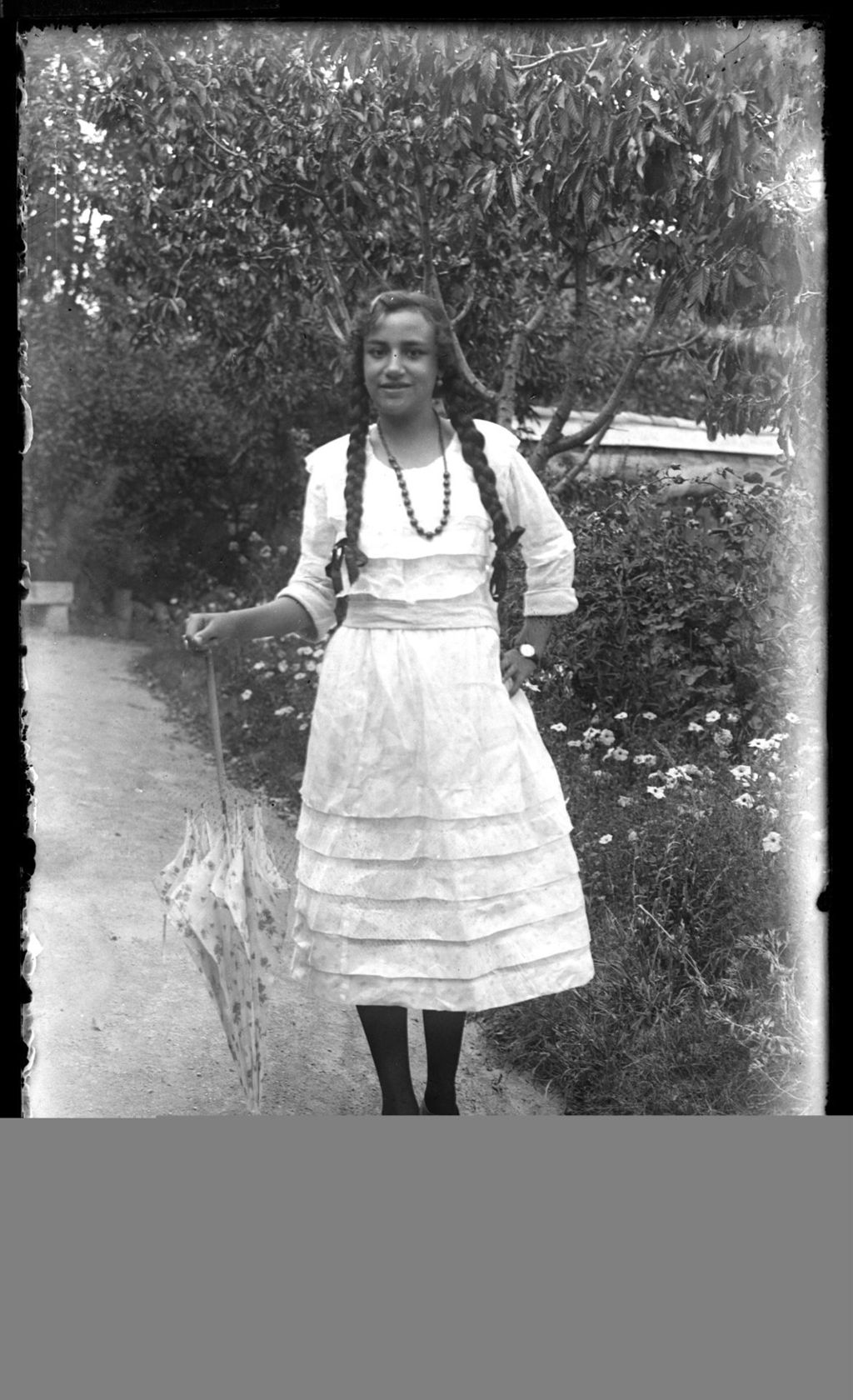 JOVEN CON TRENZAS Y PARASOL.