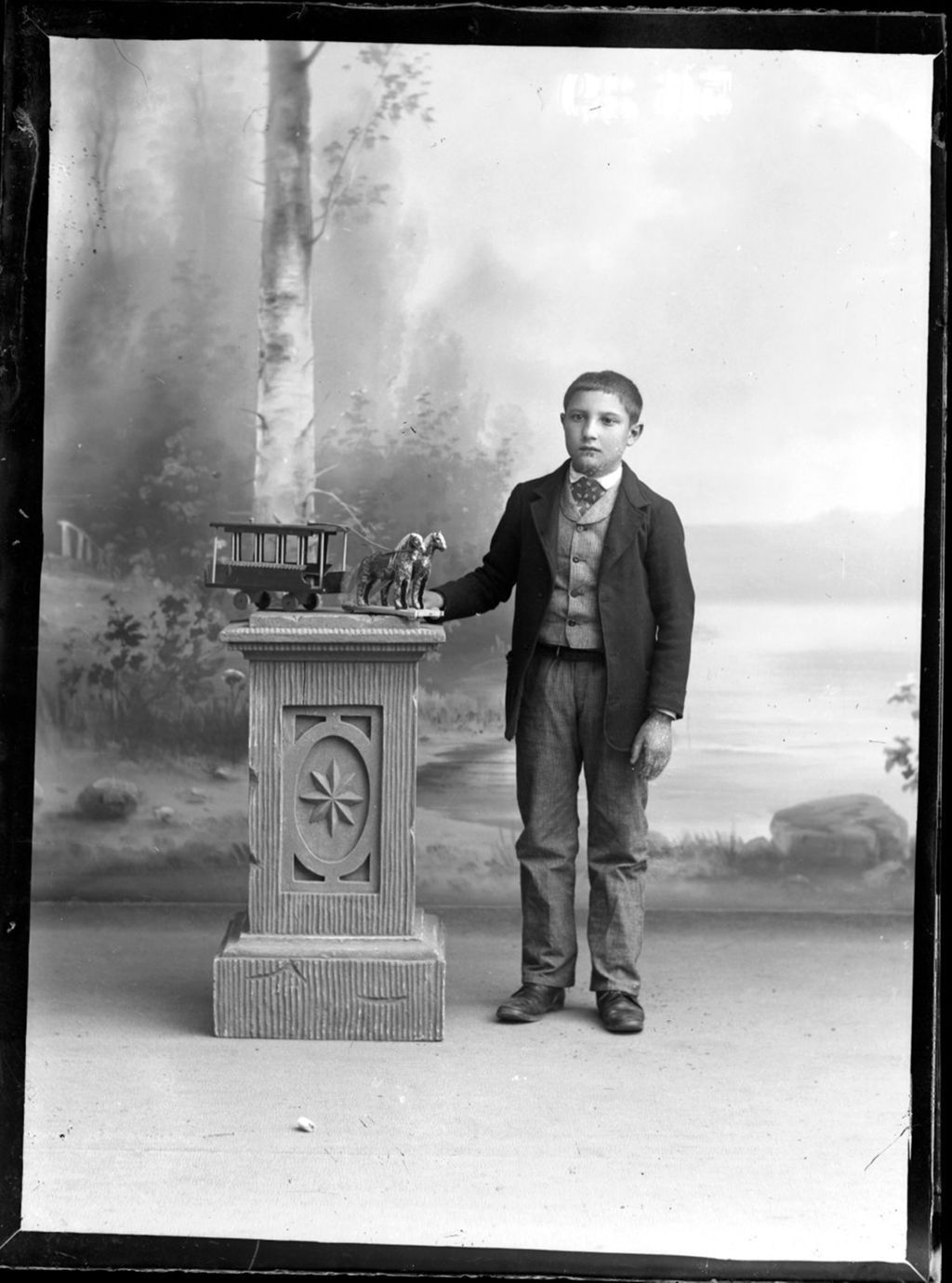 NIÑO CON JUGUETE DE TRANVIA CON CABALLOS.