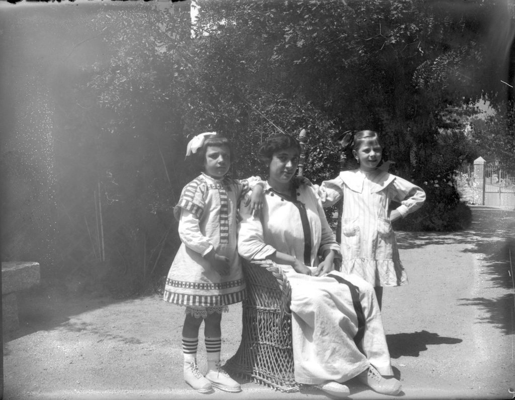 MUJER CON NIÑAS EN EL JARDÍN